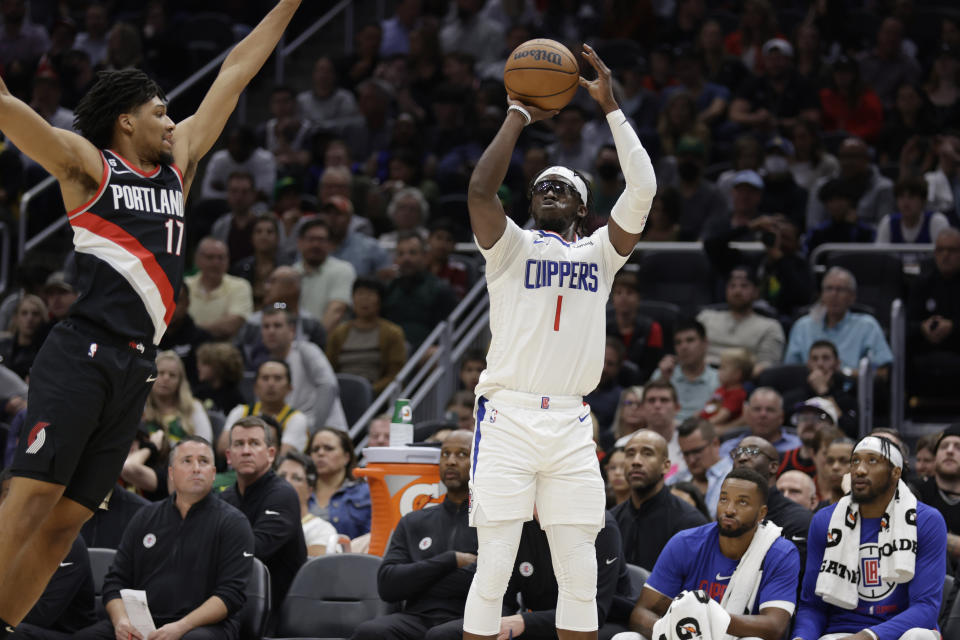 Los Angeles Clippers' Reggie Jackson shoots with Portland Trail Blazers' Shaedon Sharpe defending during the first half of a preseason NBA game on Oct. 3, 2022, in Seattle. (AP Photo/John Froschauer)