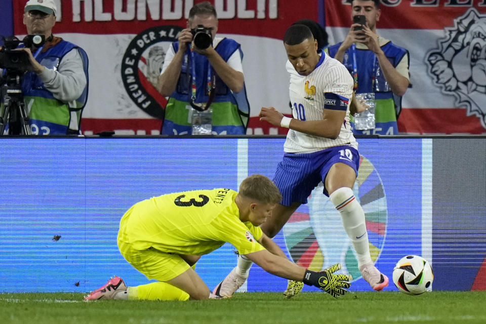 Austria's goalkeeper Patrick Pentz, challenges for the ball with Kylian Mbappe of France during a Group D match between Austria and France at the Euro 2024 soccer tournament in Duesseldorf, Germany, Monday, June 17, 2024. (AP Photo/Alessandra Tarantino)