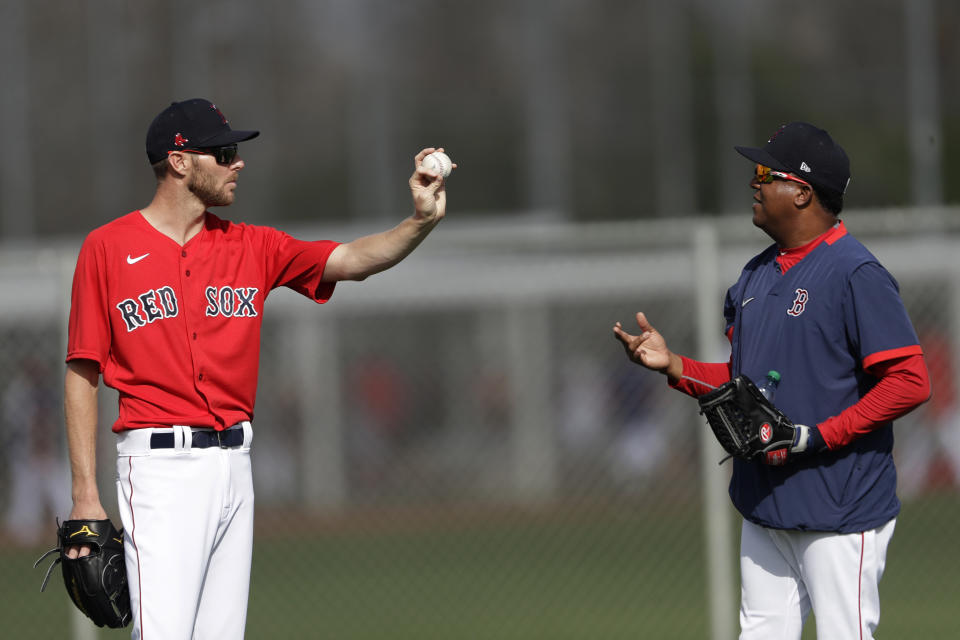 Boston Red Sox starting pitcher Chris Sale, left, talks with Pedro Martinez during spring training baseball camp Wednesday, Feb. 19, 2020, in Sarasota, Fla. (AP Photo/John Bazemore)