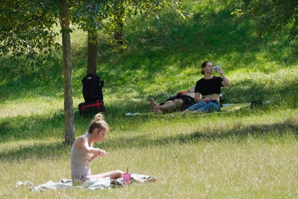 People rest in a park in Warsaw, Poland, on Saturday, July 15. (AP)