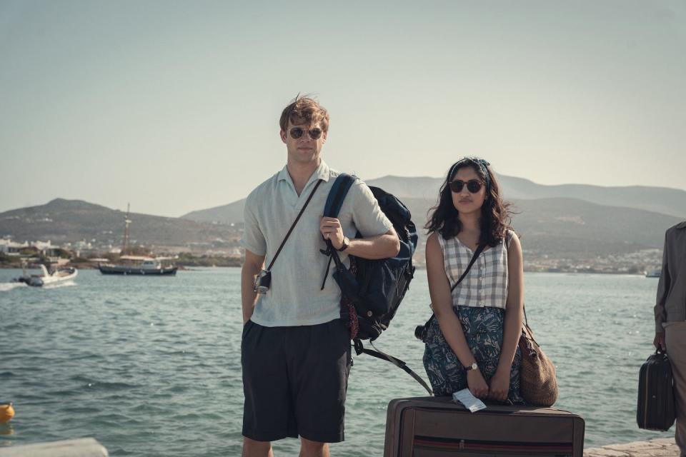 a man and woman with luggage by the water