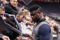 New Orleans Pelicans forward Zion Williamson signs autographs during warmups of an NBA basketball game against the Detroit Pistons, Monday, Jan. 13, 2020, in Detroit. (AP Photo/Carlos Osorio)