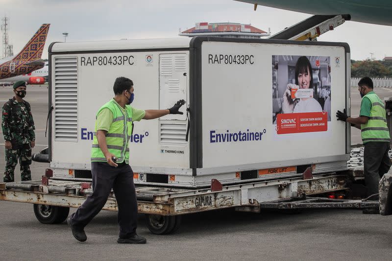 Staff arrange containers of COVID-19 vaccines at Soekarno-Hatta Airport