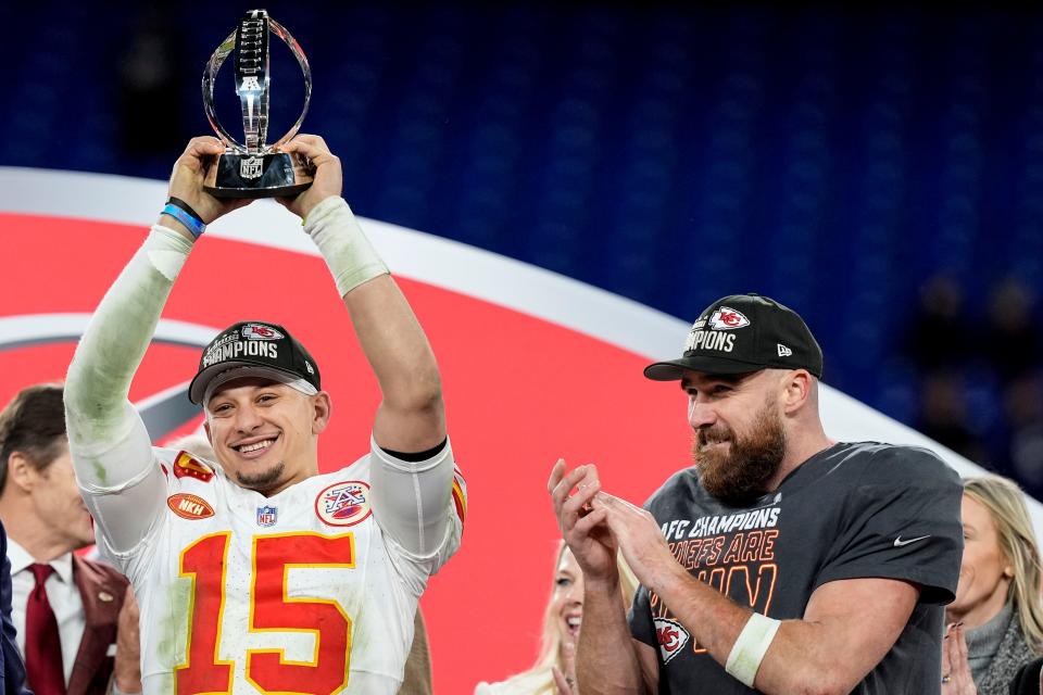 Kansas City Chiefs quarterback Patrick Mahomes (15) holds the Lamar Hunt trophy as Chiefs tight end Travis Kelce looks on after the team's AFC Championship game 17-10 victory over the Baltimore Ravens, on Jan. 28, 2024, in Baltimore.