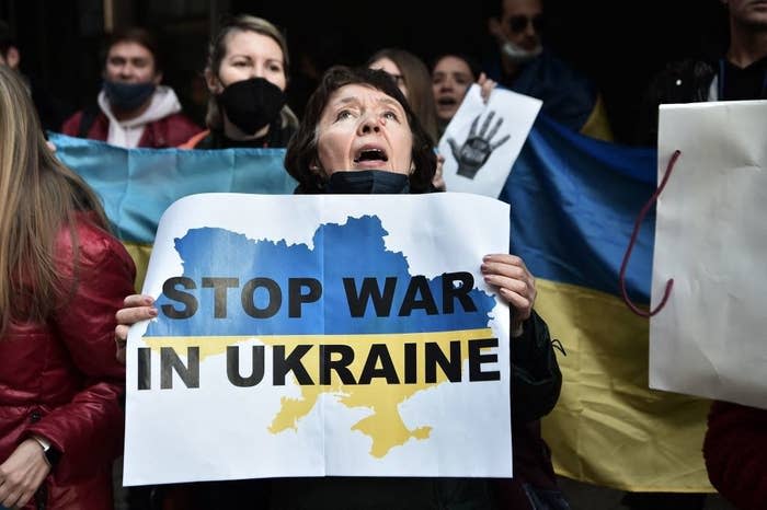 A group of protestors and a woman holding a sign that says, "Stop War in Ukraine"