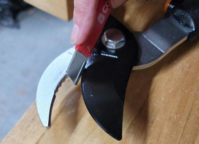 Using a blade sharpener to sharpen garden loppers.