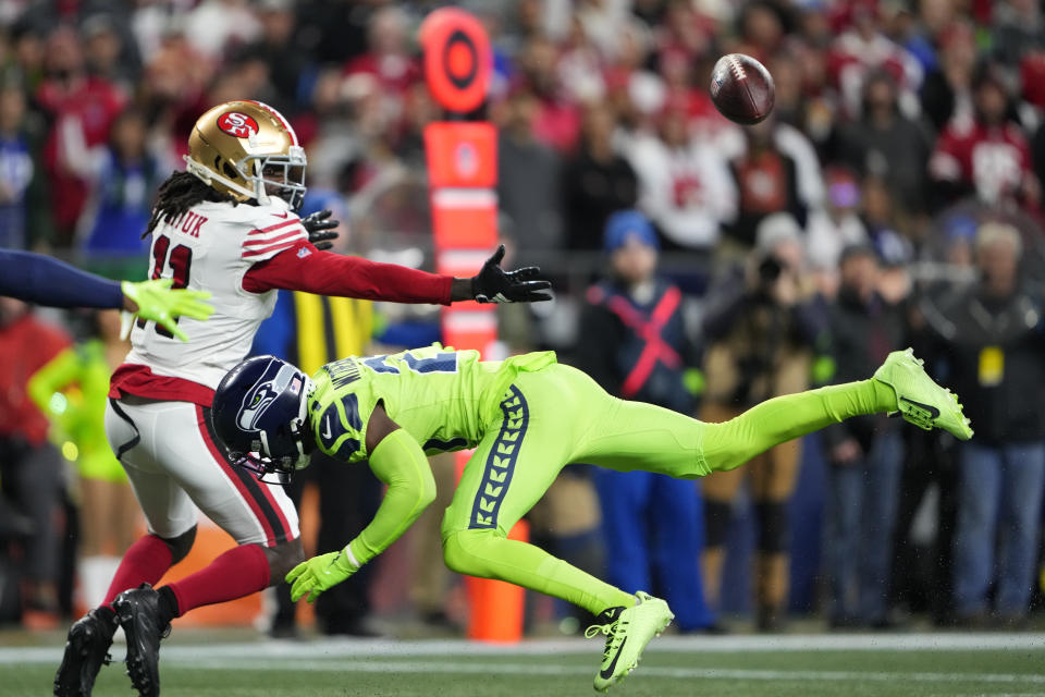 Seattle Seahawks cornerback Devon Witherspoon (21) breaks up a pass intended for San Francisco 49ers wide receiver Brandon Aiyuk (11) during the first half of an NFL football game, Thursday, Nov. 23, 2023, in Seattle. (AP Photo/Lindsey Wasson)