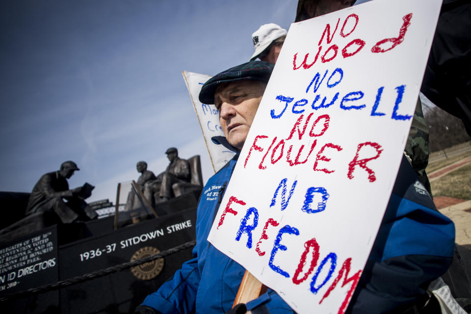 Genesee County Clerk-Register John Gleason protests alongside a dedicated handful United Auto Workers retirees during a protest against former UAW 1-C Director Norwood Jewell, Tuesday, April 2, 2019 at Sitdowners Memorial Park in Flint, Mich. Jewell is expected to enter a plea agreement Tuesday, on charges related to misuse of union workers' training funds. The retired UAW workers who protested are asking for all mentions of Jewell's name to be removed from the park. (Jake May/The Flint Journal via AP)