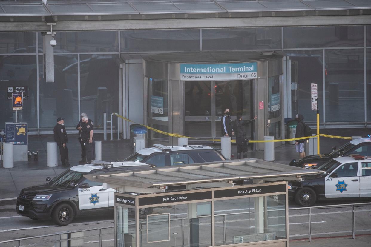 Police stand outside San Francisco International Airport after the shooting Thursday.