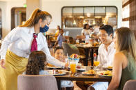 New measures are in place to promote health and well-being in table-service restaurants at Walt Disney World Resort in Lake Buena Vista, Fla. Cast members wear appropriate face coverings at all times, while guests can only remove their face coverings while sitting at their table. (Disney/Matt Stroshane)