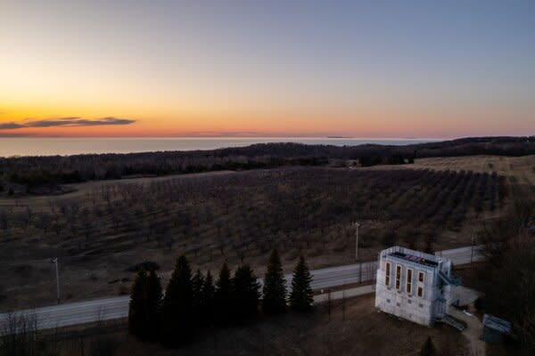 Perched on a one-acre hillside rising above the rolling topography, the home frames striking views of Lake Michigan, the Manitou Islands, and the Crib Lighthouse.