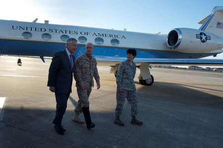 Then U.S. Secretary of Defense Chuck Hagel (L), walks with Vice Admiral Robert Harward (C) and Colonel Kelly Martin, vice commander of 6th Air Mobility Wing, after landing at MacDill Air Force Base, Tampa, Florida, U.S., March 21, 2013. Courtesy Erin A. Kirk-Cuomo/Department of Defense/Handout via REUTERS