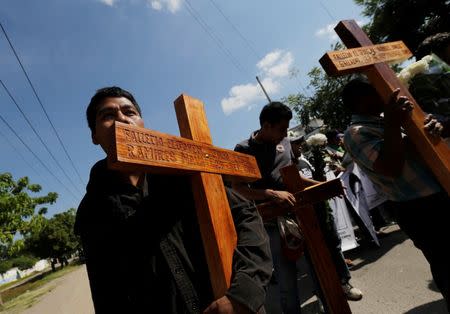 Relatives of missing students of the Ayotzinapa Teacher Training College, Raul Isidro Burgos, participate in a march as they carry crosses with the names of three students who were killed during clashes with police in late September, in Iguala October 27, 2014. REUTERS/Henry Romero