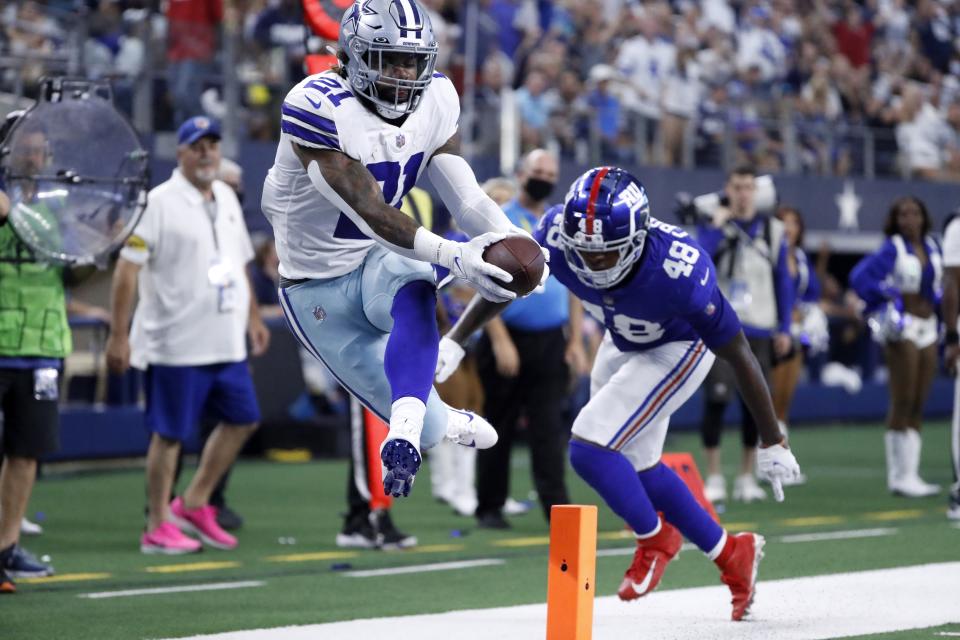 Dallas Cowboys running back Ezekiel Elliott (21) reaches into the end zone to score a touchdown after getting through New York Giants linebacker Tae Crowder (48) in the second half of an NFL football game in Arlington, Texas, Sunday, Oct. 10, 2021. (AP Photo/Roger Steinman)