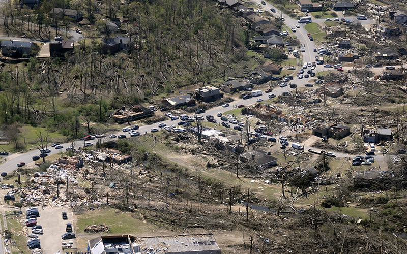 Cars line up along the road as tornado cleanup continues