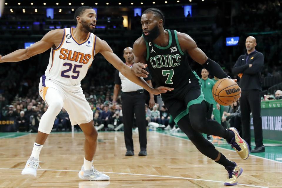 Boston Celtics' Jaylen Brown (7) drives past Phoenix Suns' Mikal Bridges (25) during the first half of an NBA basketball game, Friday, Feb. 3, 2023, in Boston. (AP Photo/Michael Dwyer)