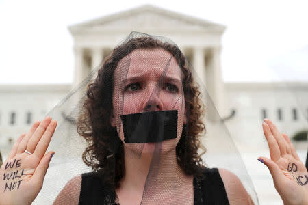 A demonstrator stands with the words "We Will Not Go Back" written on her hands outside the U.S. Supreme Court after the U.S. Senate voted to confirm the Supreme Court nomination of Judge Brett Kavanaugh on Capitol Hill in Washington, U.S., October 6, 2018. REUTERS/Jonathan Ernst