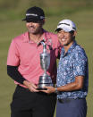 United States' Collin Morikawa, right with his caddie Jonathan Jakovac as he holds up the claret jug trophy as they pose for photographers on the 18th green after winning the British Open Golf Championship at Royal St George's golf course Sandwich, England, Sunday, July 18, 2021. (AP Photo/Ian Walton)