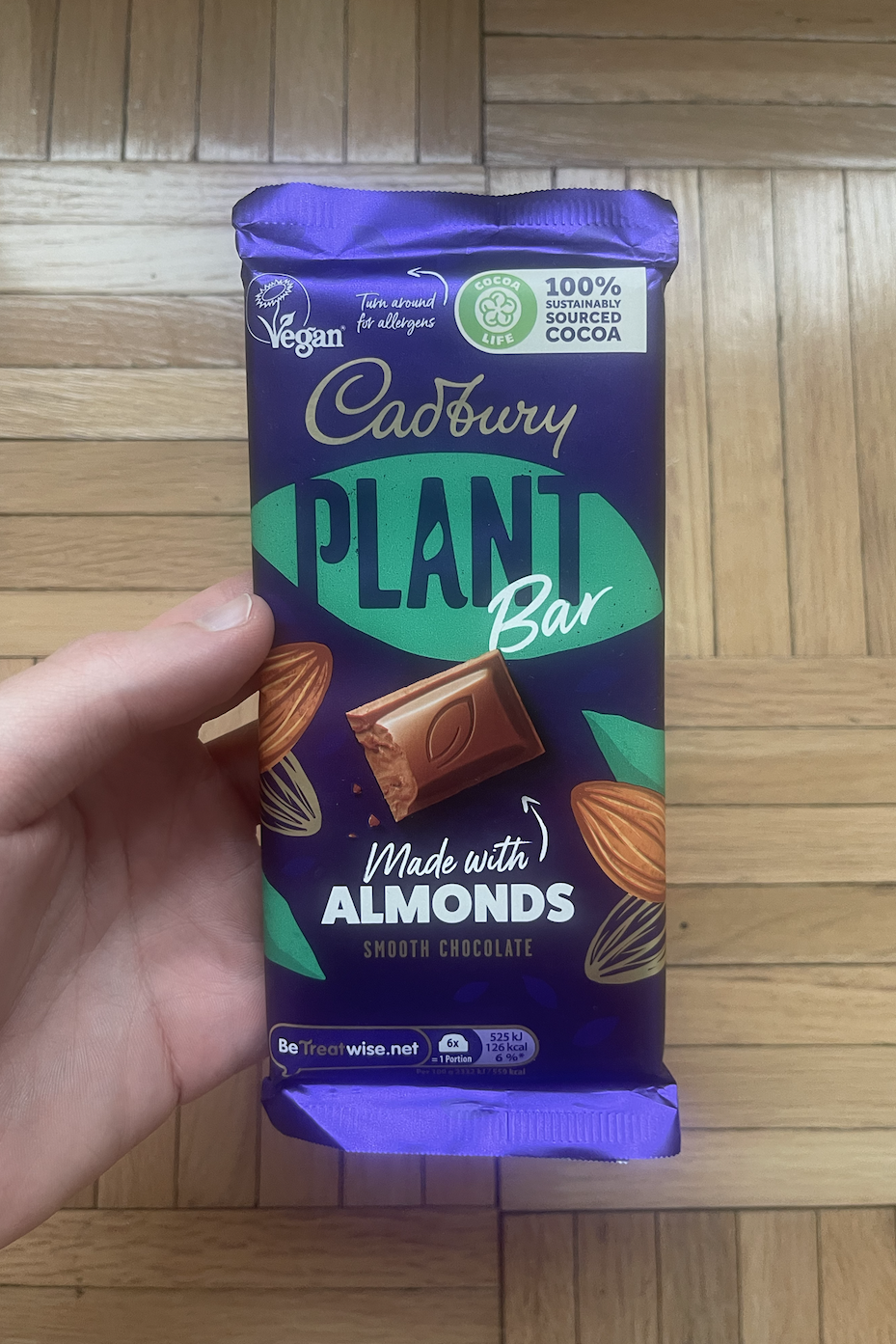 Hand holding a Cadbury almond chocolate bar package