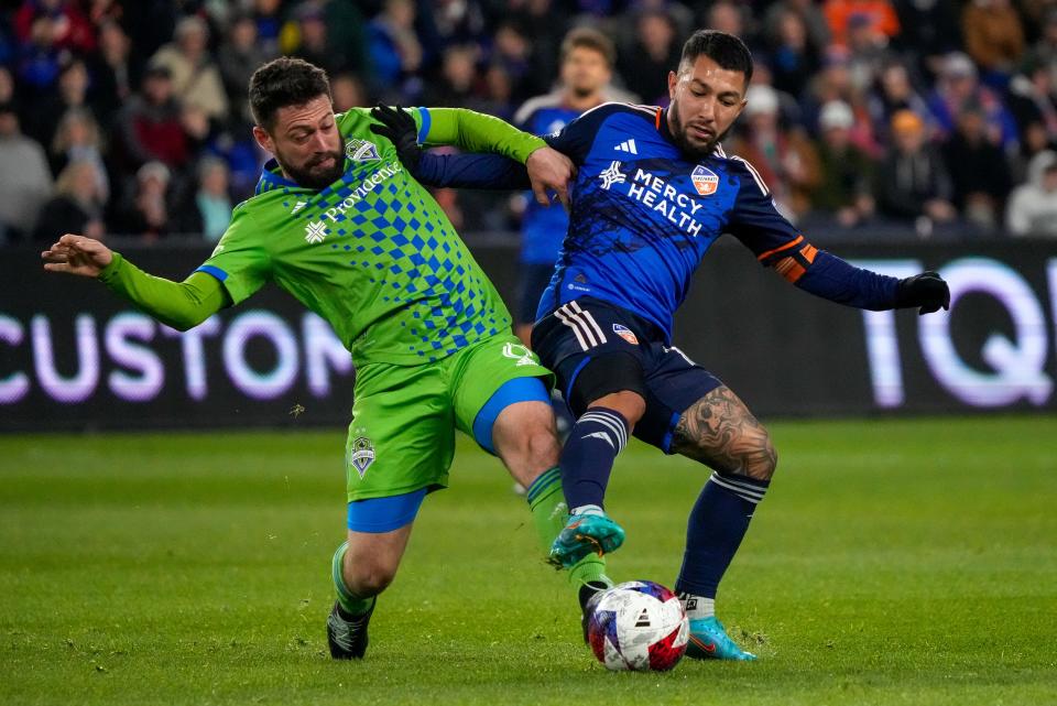 Seattle Sounders midfielder João Paulo (6) and FC Cincinnati midfielder Luciano Acosta (10) shove for the ball in the first half of the MLS match between FC Cincinnati and the Seattle Sounders at TQL Stadium in Cincinnati on Saturday, March 11, 2023. The match was tied, 0-0, at halftime.