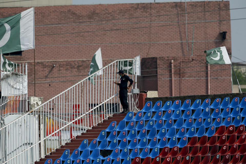 A Pakistani police officer stands guard an enclosure in the Pindi Cricket Stadium before the start of the first one day international cricket match between Pakistan and New Zealand, in Rawalpindi, Pakistan, Friday, Sept. 17, 2021. The limited-overs series between Pakistan and New Zealand has been postponed due to security concerns of the Kiwis. (AP Photo/Anjum Naveed)