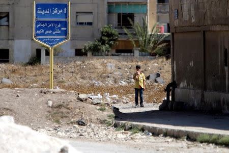 A boy stands near the entrance of the Waer district in the central Syrian city of Homs, Syria September 19, 2016. REUTERS/Omar Sanadiki