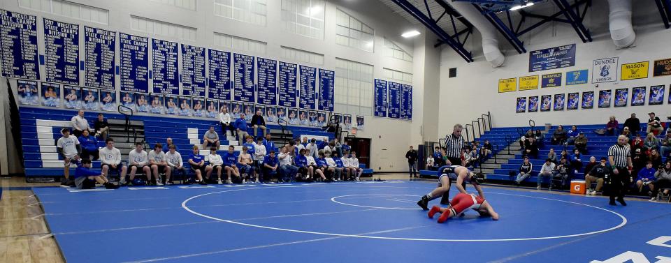 The Dundee Vikings state champion wrestling banners hang in the gymnasium, along with ones for baseball and softball as senior Cameron Chinavare wrestles against Milan on Feb. 7, 2024.