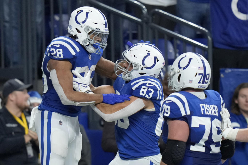 Indianapolis Colts running back Jonathan Taylor (28) is congratulated by Kylen Granson (83) and Eric Fisher (79) after scoring on a 67-yard touchdown run during the second half of an NFL football game against the New England Patriots Saturday, Dec. 18, 2021, in Indianapolis. (AP Photo/AJ Mast)