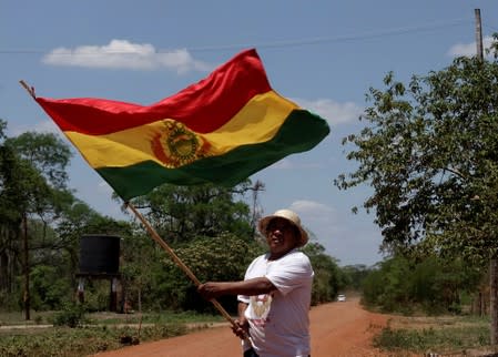 A man holds a Bolivian flag during the 10th Indigenous March to defend Mother Earth near San Jose