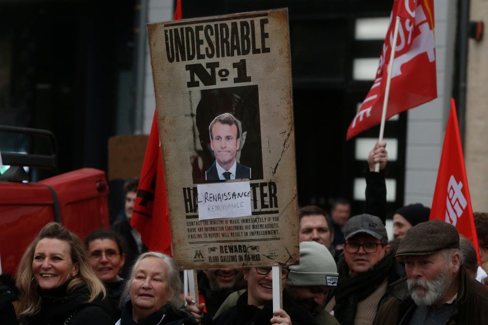 Protesters hold a placard with a portrait of Emmanuel Macron during a demonstration against plans to push back France's retirement age, in Lille, northern France, Saturday, Feb. 11, 2023.