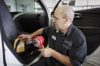 Technician Dan Lutka works on the seat belt of a Chevy Traverse at Raymond Chevrolet because of a recall in Antioch, Illinois, July 17, 2014. REUTERS/John Gress
