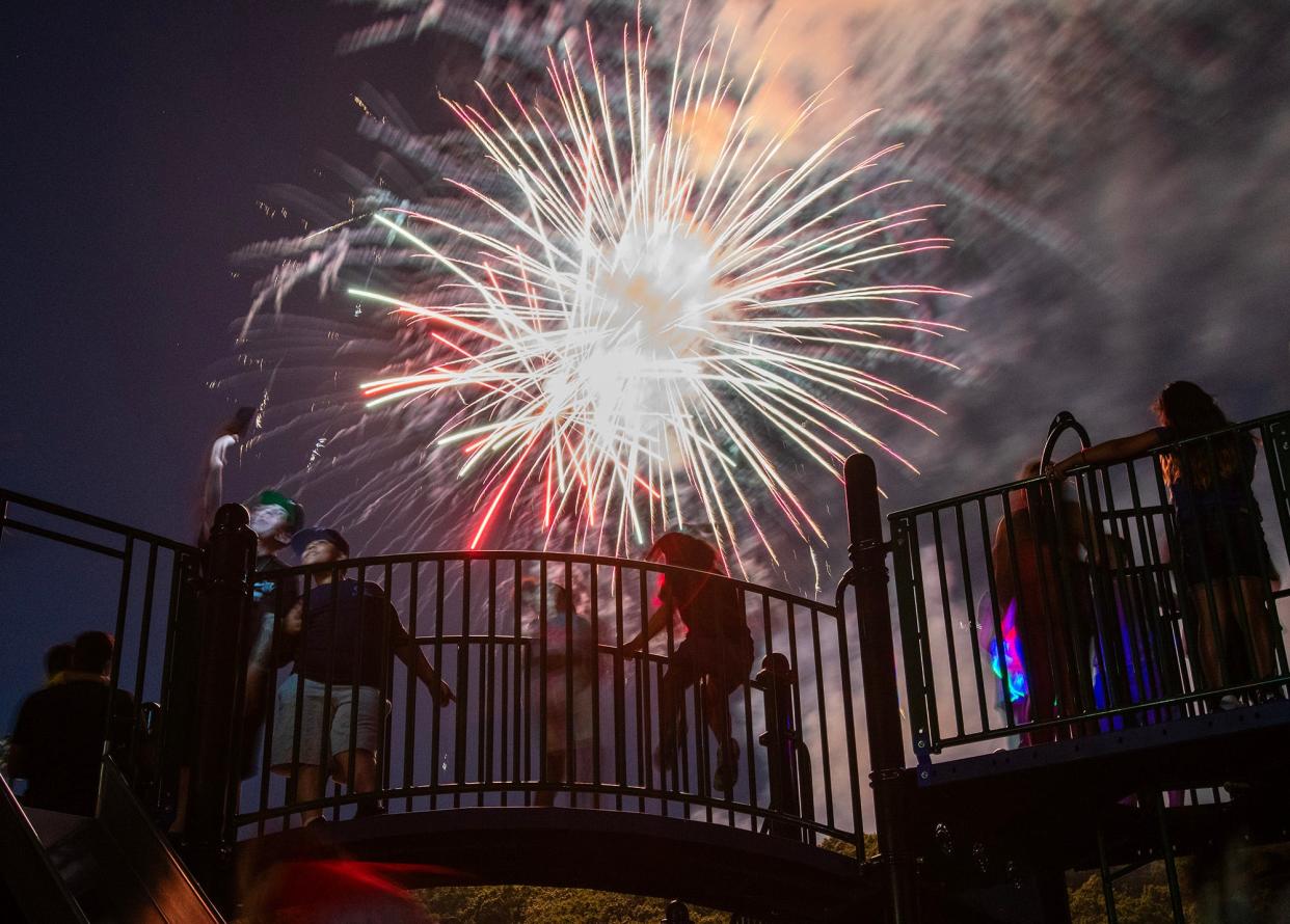 Children watch fireworks from the top of a play structure in Cristoforo Colombo Park during Worcester's 2023 Independence Day Fireworks Celebration.