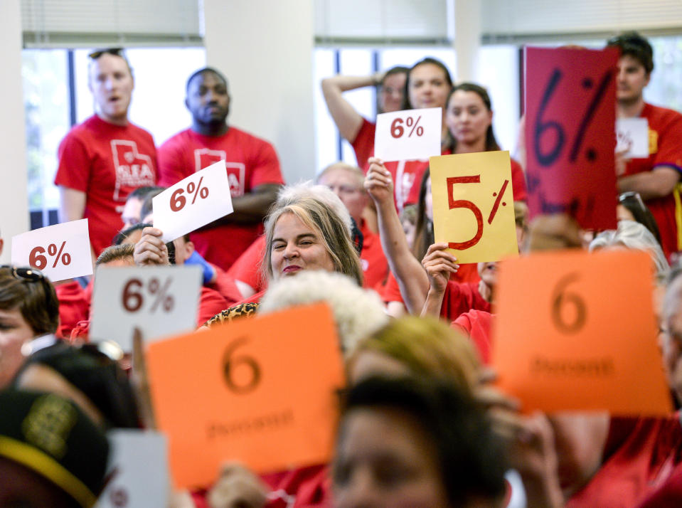 In this June 4, 2019 photo, teachers walk out of the public comment period at the Salt Lake City School District meeting regarding salary negotiations, in Salt Lake City. Across the country, teachers and school districts alike are grappling with the latest political and economic realities of educator pay. (Leah Hogsten/The Salt Lake Tribune via AP)