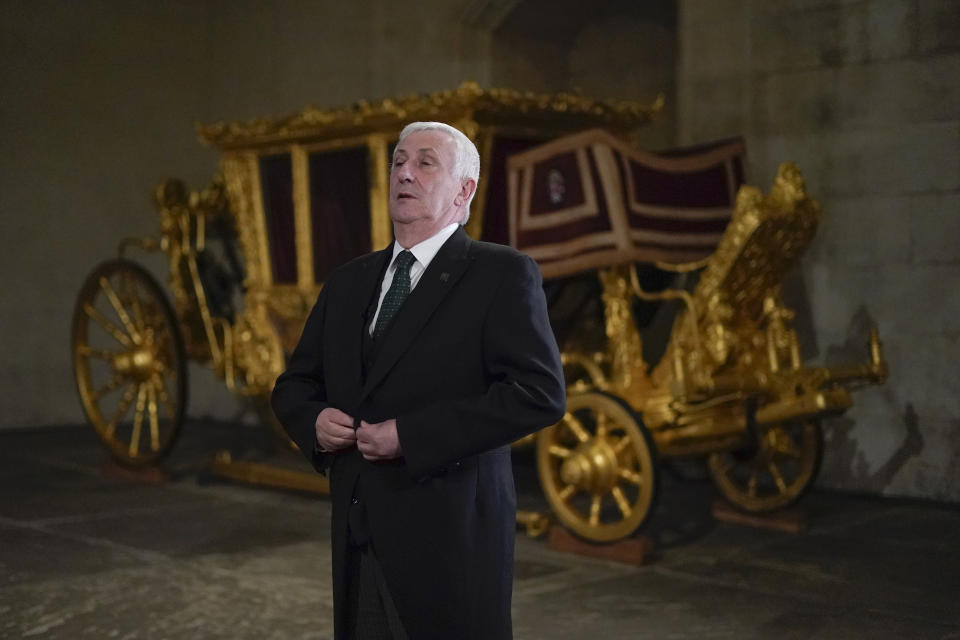 Britain's Speaker of the House of Commons Lindsay Hoyle stands next to the Speaker's State Coach as it returns to Westminster, ahead of the coronation of Britain's King Charles III, in London, Sunday, April 30, 2023. The gilded coach, which was last seen in the historic Westminster Hall in 2005, will be on display once again from 2 May to the Autumn, to commemorate the crowning of King Charles III. (AP Photo/Alberto Pezzali)