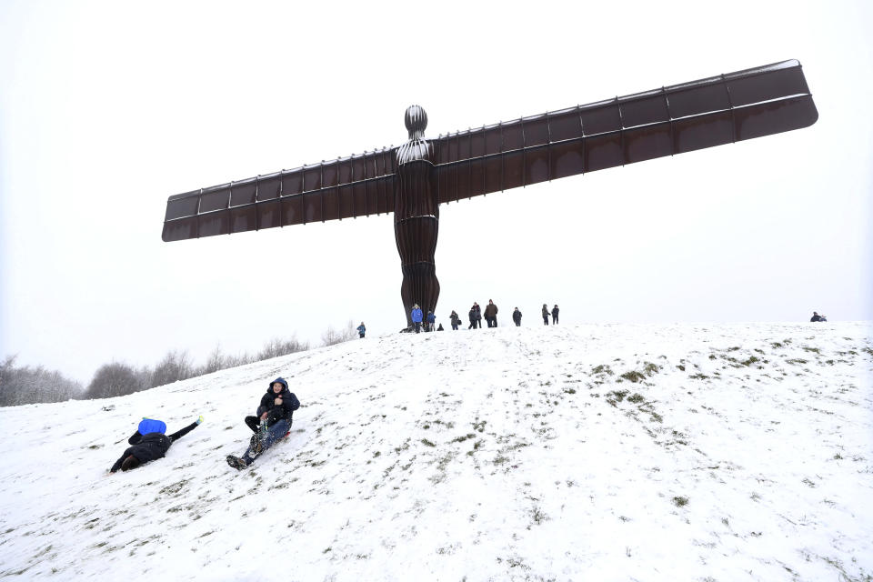 People sledge under the Angel of the North in Gateshead, England. (Owen Humphreys/PA via AP)