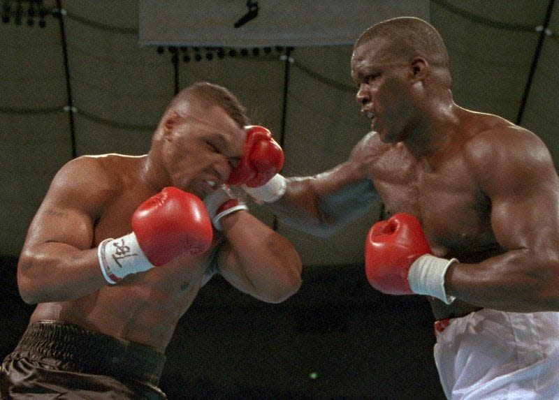 In this Feb. 11, 1990, file photo, James "Buster" Douglas, right, hits Mike Tyson with a hard right in the face during their world heavyweight title bout at the Tokyo Dome in Tokyo.  Douglas, a Columbus native, is scheduled to attend the Brawl at the Hall of Fame Village boxing event in Canton on March 11.