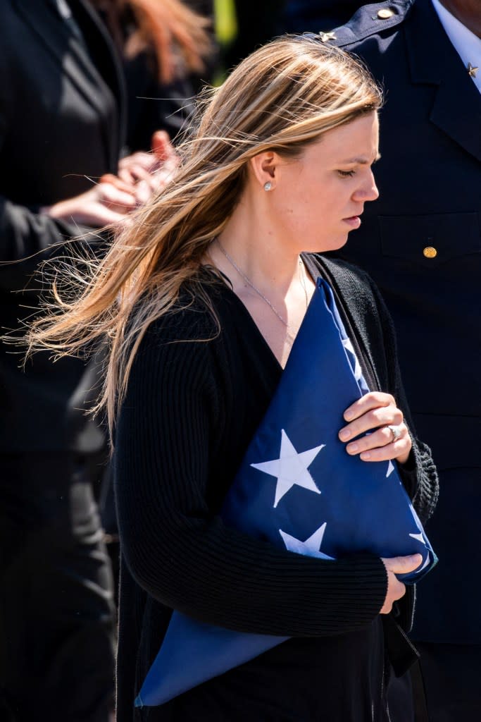 Stephanie Diller with a flag presented to her at the funeral. REUTERS