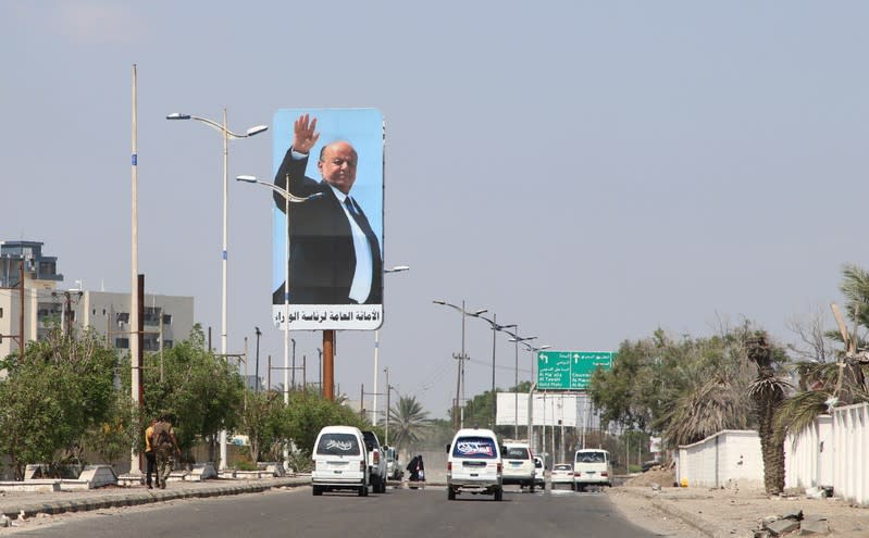 Cars drive past a billboard with a poster of Yemen's President Abd-Rabbu Mansour Hadi in Aden