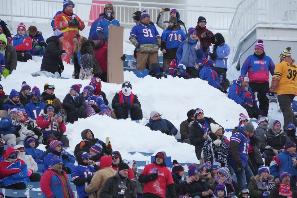 Buffalo Bills fans sit in snow during the 2024 AFC wild-card game against the Pittsburgh Steelers at Highmark Stadium in Orchard Park, New York.