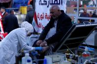 Jassem, 24, an Iraqi nurse helps a man in Baghdad