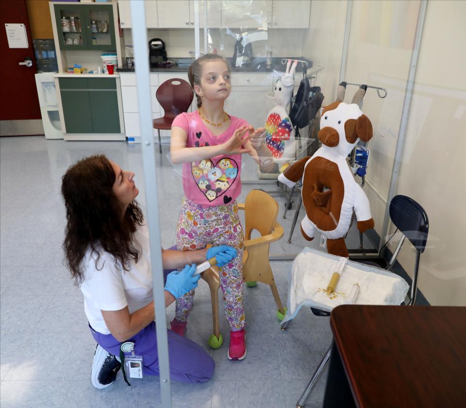 Suzanne Vogel, R.N., the lede nurse for Rockland BOCES, feeds Emily Licari, 11, with a syringe and a tube in the nurses office at the Jesse J. Kaplan School in West Nyack, Oct. 5, 2023.