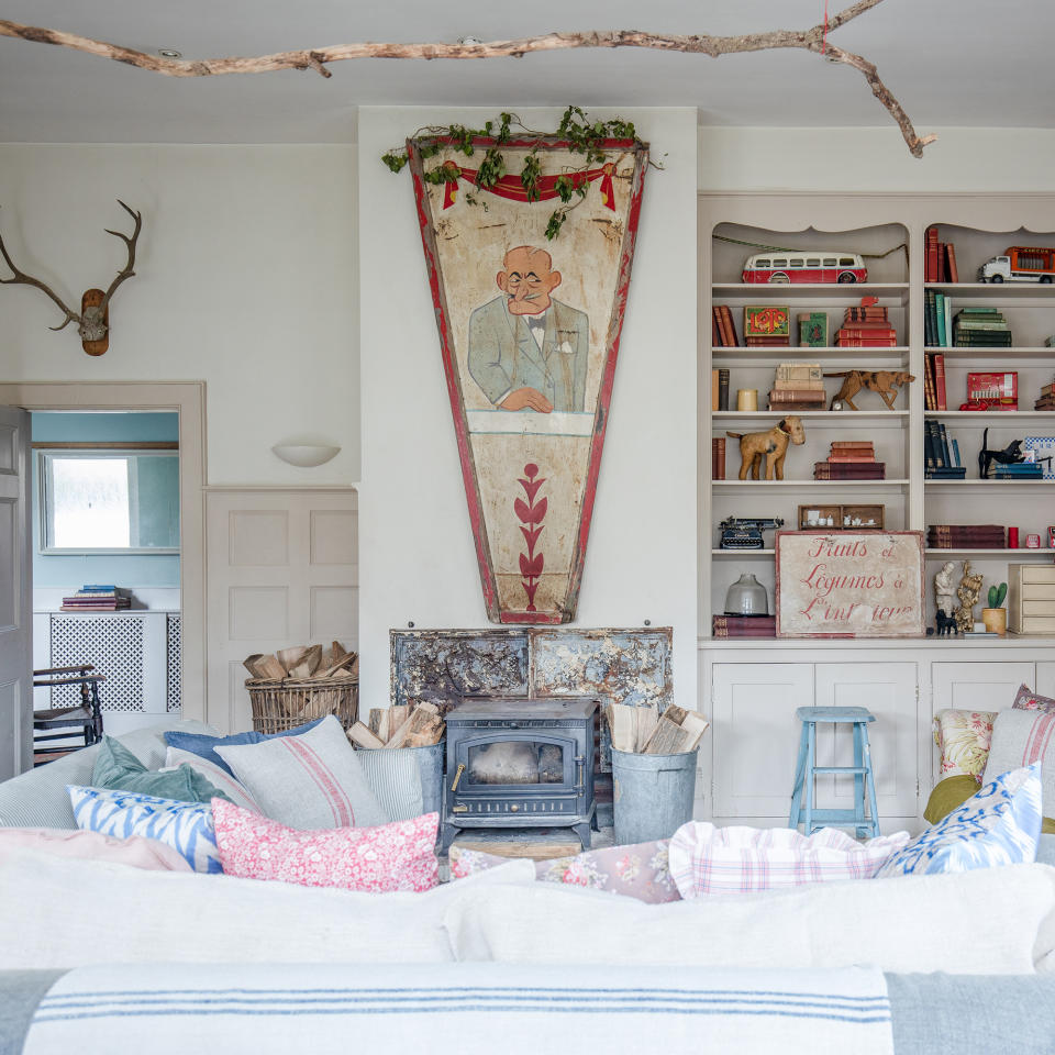 wood burner in fireplace of a vintage living room with bookshelves beside