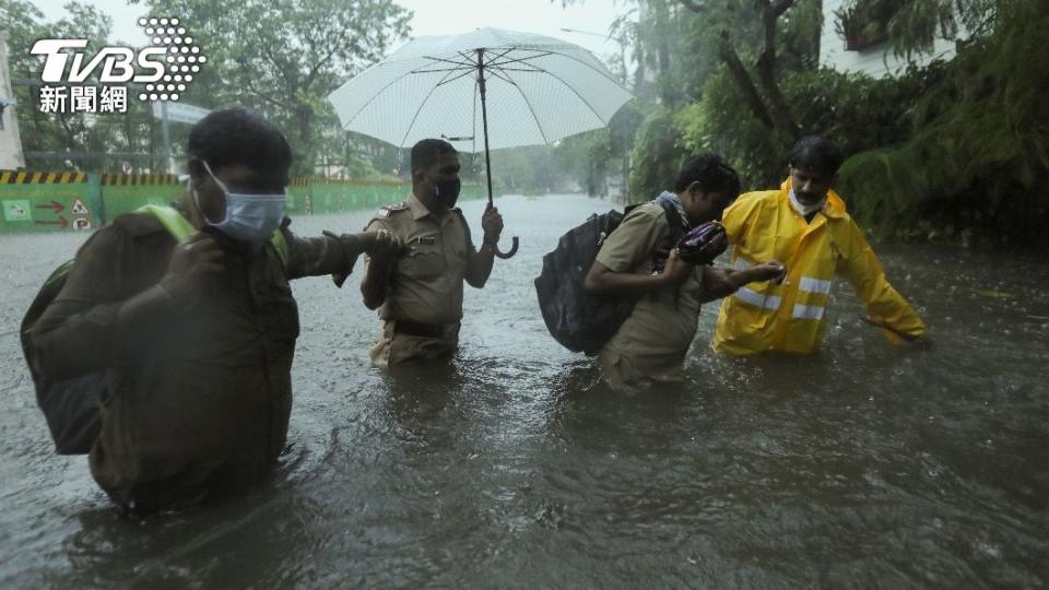 印度日前遭遇強烈颱風，多處地區淹水成災，當地警方協助民眾撤離。（圖／達志影像路透社）