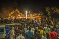 Rescue workers search for survivors in the debris after a five-story building collapsed in Mahad of Raigad district in the western state of Maharashtra. (Photo by Imtiyaz Shaikh/Anadolu Agency via Getty Images)