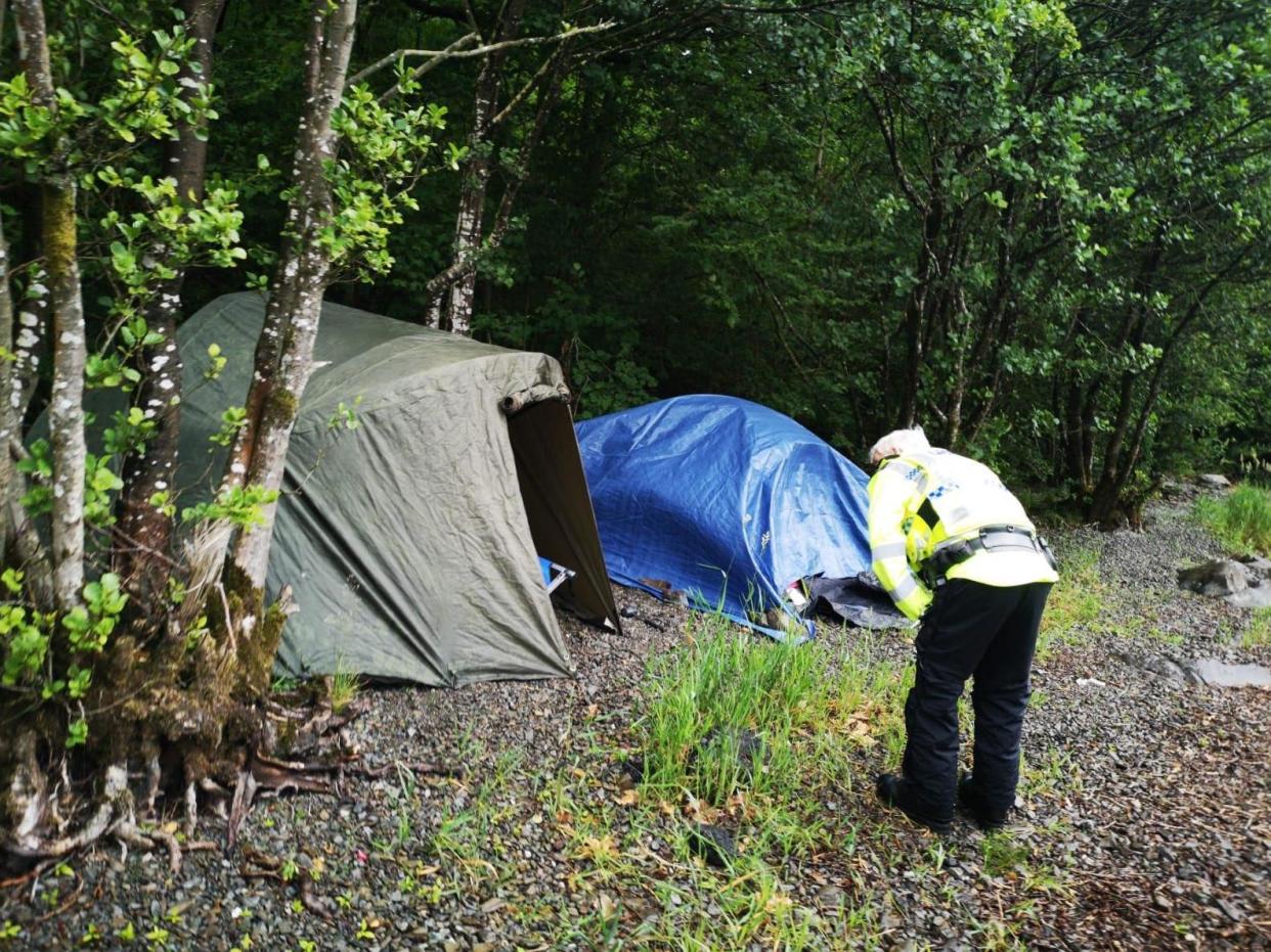 An officer speaks to people illegally camping in the Lake District. Overnight stays are not yet allowed until coronavirus lockdown measures ease further on 4 July: Tony Watson