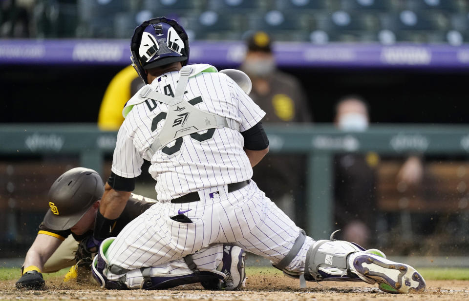 Colorado Rockies catcher Elias Diaz, front, tags out San Diego Padres' Jake Cronenworth during the eighth inning of the second game of a baseball doubleheader Wednesday, May 12, 2021, in Denver. The Rockies won 3-2. (AP Photo/David Zalubowski)