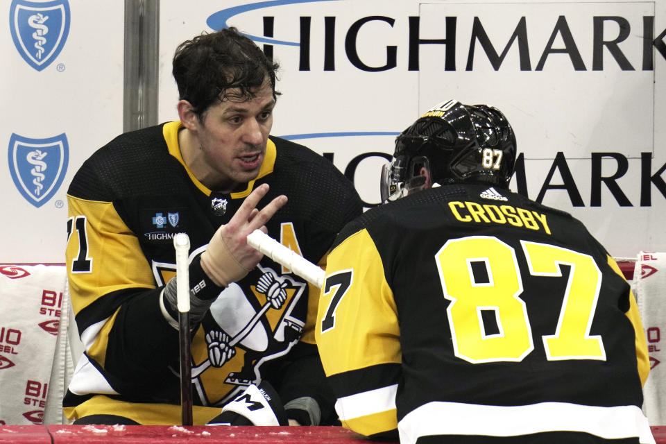 Pittsburgh Penguins' Evgeni Malkin (71) talks with teammate Sidney Crosby during a timeout in the third period of an NHL hockey game against the Washington Capitals in Pittsburgh, Saturday, March 25, 2023. (AP Photo/Gene J. Puskar)