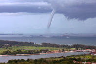 A waterspout moves across ships at sea just several hundred meters south of the coast of Singapore May 25, 2007. REUTERS/Mia Shanley