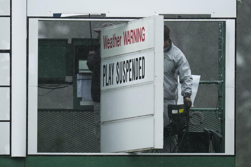 A course worker put out a play suspended sign on the scoreboard on the eighth hole during the weather delayed third round of the Masters golf tournament at Augusta National Golf Club on Saturday, April 8, 2023, in Augusta, Ga. (AP Photo/Jae C. Hong)