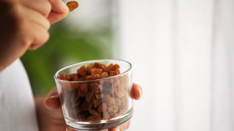 Person holding container of raisins 